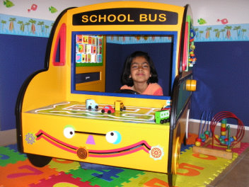 Image of a kid in a toy school bus at Fremont Dental Office